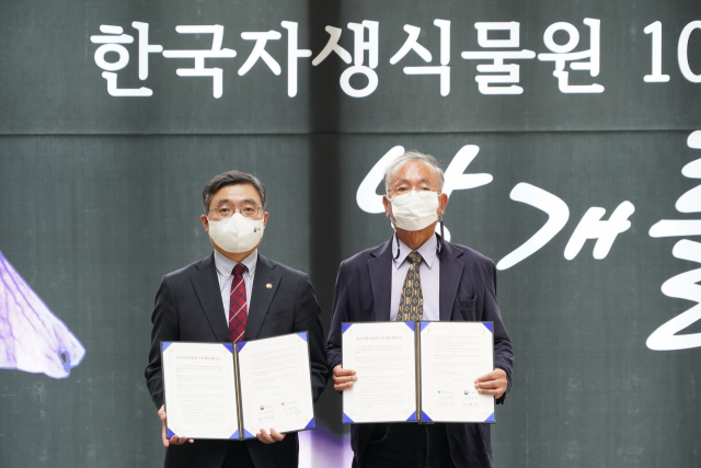 최병암(사진 왼쪽) 산림청장과 김창열(″오른쪽) 한국자생식물원장이 한국자생식물원 기부 협약서에 서명한 뒤 기념촬영을 하고 있다. 사진제공=산림청
