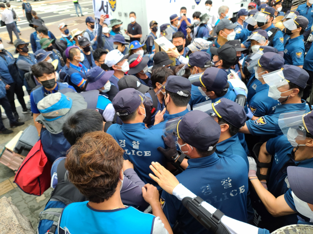 지난달 15일 서울 영등포구 여의도공원 열린 택배노조 집회 현장에서 경찰과 민주노총 노조원이 몸싸움을 벌이고 있다./허진 기자