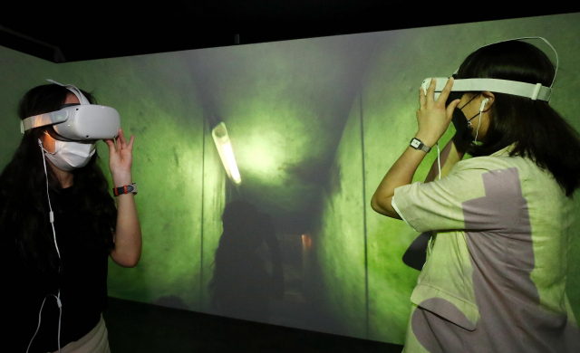 지난달 24일 서울 동대문구 콘텐츠문화광장에서 열린 '한국 : 입체적 상상' 전시 사전 체험행사에서 한 관계자가 VR(가상현실) 기기를 이용한 봉준호 감독의 영화 '기생충' 실감콘텐츠의 체험 시범을 보이고 있다. /연합뉴스