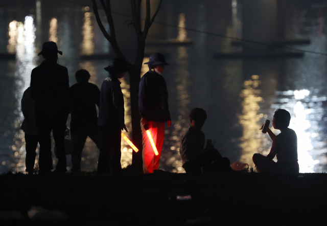 지난 6일 오후 서울 여의도 한강공원에서 서울시 관계자들이 야간 야외 음주 금지 계도활동을 벌이고 있다./연합뉴스