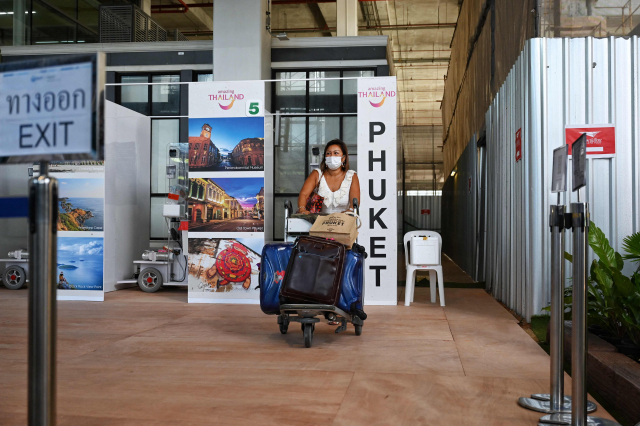 지난 1일(현지시간) 태국의 유명 휴양지 푸껫 국제공항에 도착한 직후 신종 코로나바이러스 감염증(코로나19) 검사를 마친 한 외국 관광객이 여행 가방을 실은 카트를 밀며 공항 청사를 이동하고 있다. /연합뉴스