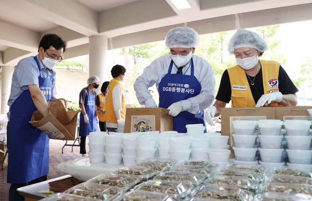 DGB대구은행 동행 봉사단이 8일 경북 상주 체육관 신관 야외에서 지역 취약 계층을 위해 삼계탕을 준비하고 있다. 이날 행사에는 봉사단원과 적십자 봉사원 등 50여 명이 참가해 취약 계층 400여 세대에 삼계탕을 전달했다. /사진 제공=DGB대구은행