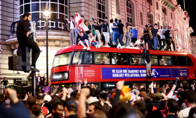 잉글랜드 팬들이 8일 축구 대표팀의 유로 2020 4강 경기 뒤 런던 피커딜리서커스를 가득 메운 채 승리의 기쁨을 만끽하고 있다. /런던=로이터연합뉴스