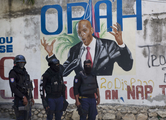 7일(현지시간) 조브넬 모이즈 대통령이 그려진 벽화 앞에 무장한 경찰들이 서 있다. /AP연합뉴스