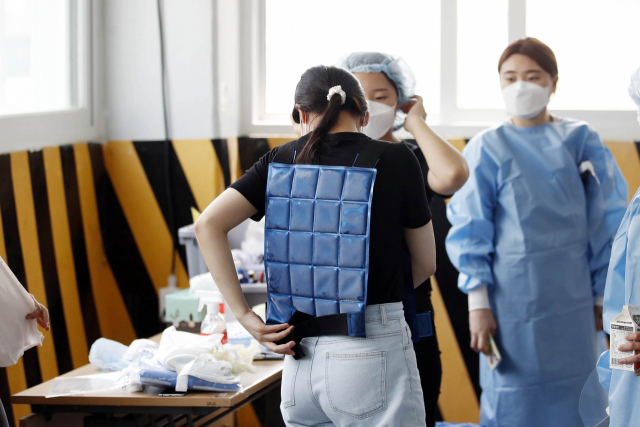 선별진료소에서 의료진들이 더위를 견디기 위해 냉 조끼를 착용하고 있다./연합뉴스