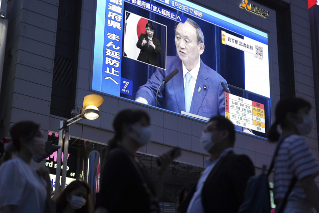 지난달 17일 일본 도쿄 한 거리의 대텽 디스플레이에서 스가 요시히데 총리의 모습이 나오고 있다./AP연합뉴스