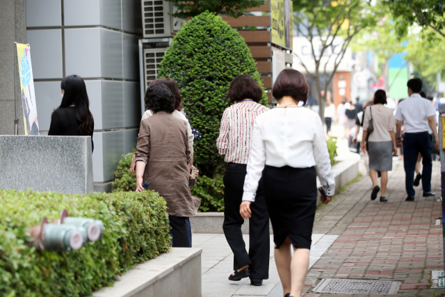 지난달 18일 광주 서구 치평동 식당가에서 직장인들이 점심 식사를 하기 위해 길을 지나고 있다. / 연합뉴스