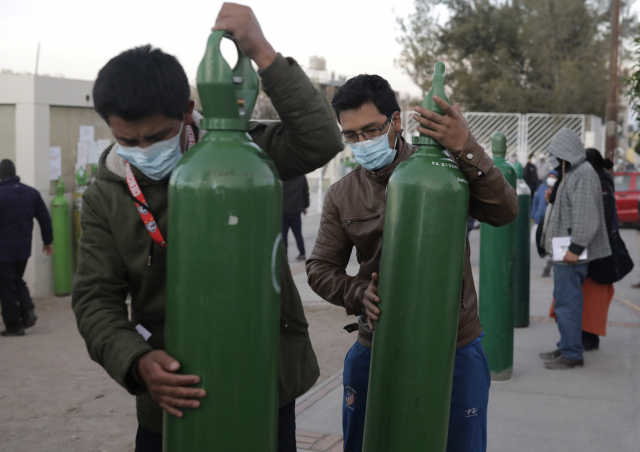 지난달 25일(현지시간) 페루 사람들이 코로나19 치료용 산소탱크 충전을 기다리고 있다./AP연합뉴스