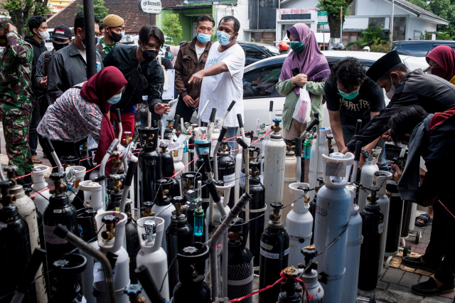 인도네시아가 신종 코로나19 확산으로 비상인 가운데 14일(현지시간) 자바섬 족자카르타의 한 산소 충전소에 의료용 산소를 구매하려는 주민들이 모여 있다. /AFP연합뉴스