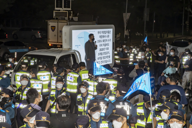 14일 밤 서울 여의도공원 인근에서 열린 ‘전국자영업자비대위, 거리두기4단계 조치 불복 기자회견’에서 최승재 국민의힘 의원이 단상에 올라 발언하고 있다. /연합뉴스