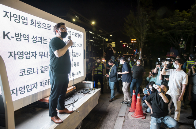 14일 밤 서울 여의도공원 인근에서 열린 ‘전국자영업자비대위, 거리두기4단계 조치 불복 기자회견’에서 김기홍 자영업자비대위 대표가 발언하고 있다. /연합뉴스