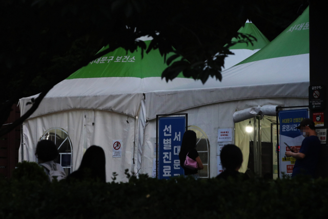 지난 14일 오후 야간 운영 중인 서울 서대문구 보건소 선별진료소를 찾은 시민들이 거리두고 앉아 검사를 기다리고 있다./연합뉴스