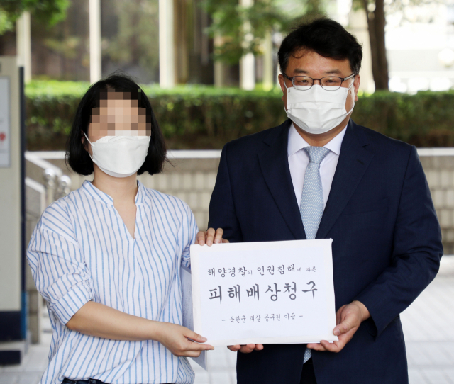 지난해 서해상에서 북한군에 피살된 공무원 이 씨의 부인 권 모(왼쪽) 씨와 김기윤 변호사가 15일 서울중앙지법에서 피해보상 청구 소송 기자회견을 하고 있다. /연합뉴스