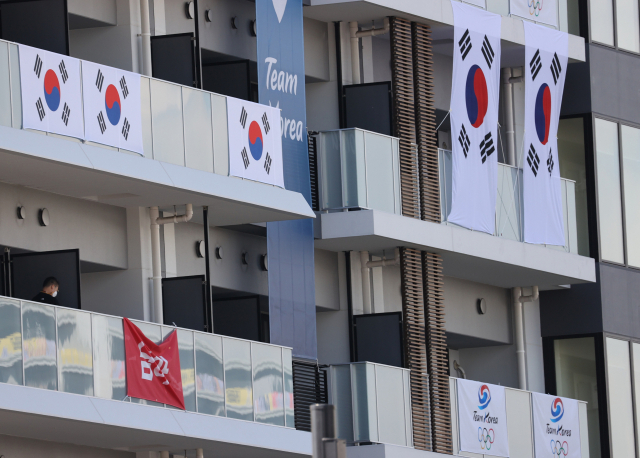 17일 도쿄 올림픽선수촌 한국선수단 아파트 거주층에서 대한체육회 직원이 '신에게는 아직 5천만 국민들의 응원과 지지가 남아 있사옵니다' 현수막을 철거하고 있다. /연합뉴스