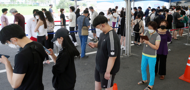 수도권발 코로나19가 전국으로 확산하는 가운데 16일 강원 강릉시 보건소 선별 진료소 앞에서 시민들이 검사를 받기 위해 기다리고 있다. /연합뉴스