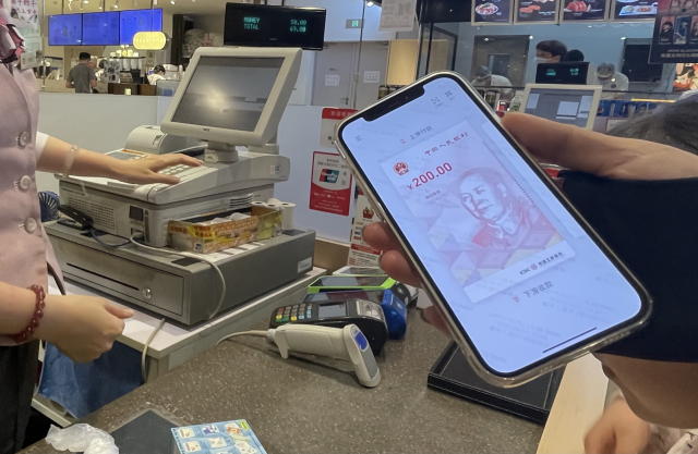 최근 중국 상하이 다카시마야(高島屋) 백화점 지하 슈퍼마켓 계산대에서 한 고객이 결제를 위해 꺼내든 스마트폰의 디지털 위안화 전자지갑 앱 화면. /연합뉴스