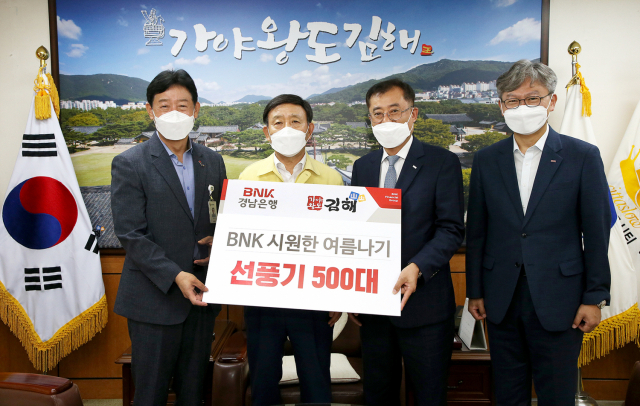 BNK경남은행 박태규 상무(사진 오른쪽 두번째)가 허성곤 김해시장( 〃 세번째)에게 ‘BNK 시원한 여름나기 선풍기 기탁 증서’를 전달하고 있다. /사진제공=경남은행