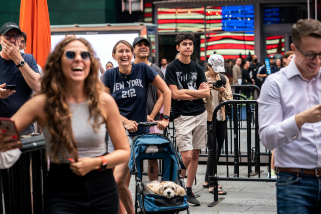 미국 뉴욕에서 사람들이 블루오리진의 우주선 발사 모습을 지켜보며 활짝 웃고 있다./로이터연합뉴스