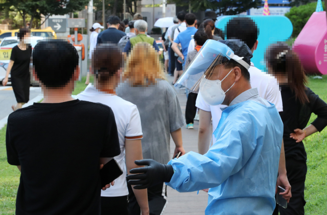 21일 오전 서울 송파구 송파구보건소에 마련된 선별진료소에 코로나19 검사를 받으려는 시민들이 대기하고 있다./연합뉴스