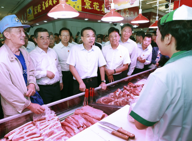 돼지고기 가격이 폭등하던 지난 2019년 8월 리커창 총리가 헤이룽장성 하얼빈의 육류 시장을 둘러보고 있다. 2년 만에 돈육 가격이 폭락했지만 아직 중국 수뇌부의 움직임은 없는 상황이다. /신화연합뉴스