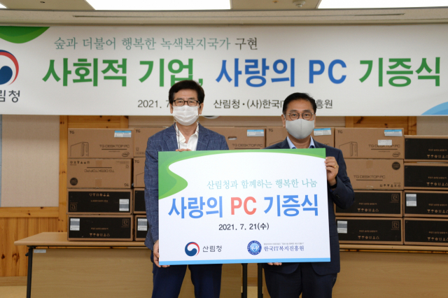 산림청 이용석(사진 오른쪽)운영지원과장이 한국아이티(IT)복지진흥원에 전산기기를 기증하고 있다. 사진제공=산림청