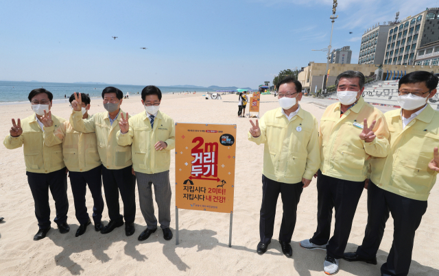 김부겸 국무총리(오른쪽 세번째)가 20일 오후 해수욕장 방역 현장점검으로 충남 보령시 대천해수욕장을 찾아 2미터 거리두기 안내문 앞에서 당부의 말을 전하고 있다./연합뉴스