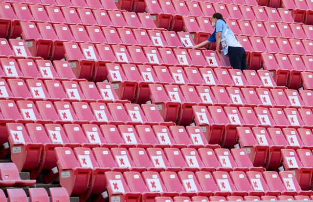 한 진행 요원이 21일 가시마 스타디움의 좌석에 착석을 금지하는 종이를 붙이고 있다. 소규모 관중 입장이 허용되지만 붙어 앉을 수는 없다. /가시마=권욱 기자