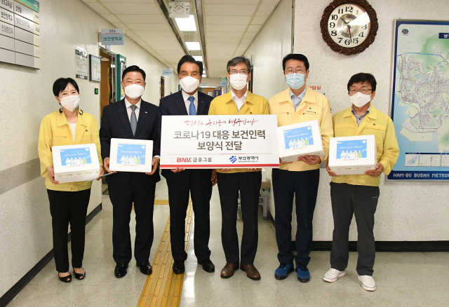 김지완(오른쪽 네 번째) BNK금융그룹 회장과 안감찬(〃 다섯 번째) 부산은행장이 21일 부산 남구보건소를 방문해 이병진(〃 세 번째) 부산광역시 행정부시장을 비롯한 관계자들에게 보양식 세트를 전달하고 보건 인력의 노고에 감사 인사를 전했다. /사진 제공=BNK금융