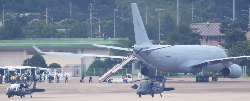 20일 오후 공군 다목적 공중급유수송기(KC-330)로 서울공항에 도착한 청해부대 34진 문무대왕함(4천400t급)의 장병들이 방역 관계자들의 안내를 받아 치료-격리시설로 향하는 버스로 이동하고 있다. /연합뉴스