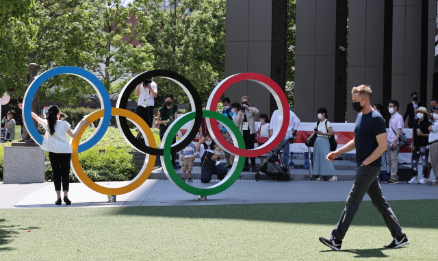 제32회 도쿄 올림픽 개막을 하루 앞둔 22일 일본 도쿄 시민들이 개막식 장소인 신주쿠구 도쿄 올림픽 스타디움 앞의 오륜기 조형물 앞에서 기념 촬영을 하고 있다. /도쿄=권욱 기자