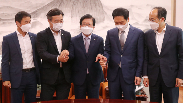 박병석(가운데) 국회의장과 여야 원내 지도부가 2차 추경안에 합의한 뒤 손을 잡고 있다.