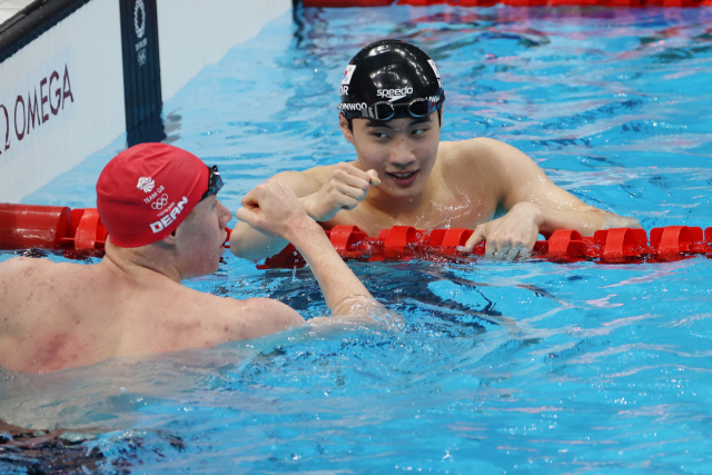황선우(오른쪽)가 25일 도쿄 올림픽 남자 자유형 200m 예선에서 조 1위로 골인한 뒤 영국 톰 딘의 축하를 받고 있다. /연합뉴스