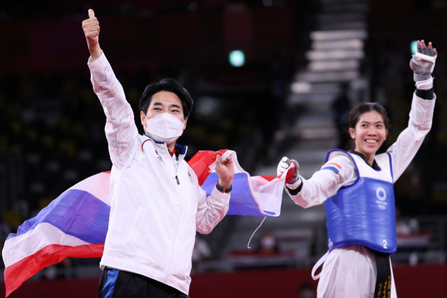 20여년 동안 태국 태권도를 이끌어 온 최영석 감독이 24일 일본 마쿠하리 메세 A홀에서 열린 도쿄올림픽 여자 태권도 49㎏급 결승에서 우승을 차지한 파니팍 선수와 세리머니를 하고 있다. /연합뉴스