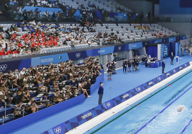26일 일본 도쿄도 소재 도쿄아쿠아틱스 센터에서 도쿄올림픽 경영 경기가 진행되고 있다. 관중석에 선수단이 관람객 대신 자리를 채우고 있고 사진기자들은 빽빽하게 앉아 취재 중이다./연합뉴스