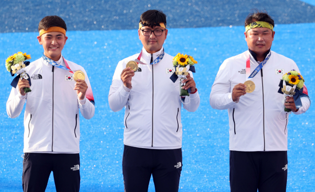 26일 일본 유메노시마 공원 양궁장에서 열린 도쿄올림픽 남자 단체전 시상식에서 한국 김제덕(왼쪽부터), 김우진, 오진혁이 금메달을 목에 걸고 기념촬영을 하고 있다./연합뉴스