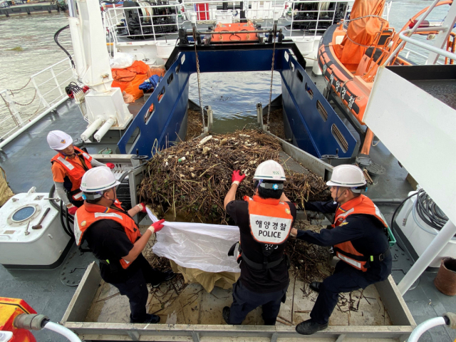 해경 직원들이 목포항 방제정에서 항구 내 쓰레기를 수거하고 있다.