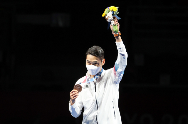 24일 일본 마쿠하리 메세홀에서 열린 도쿄올림픽 펜싱 사브르 종목에서 동메달을 차지한 김정환이 메달을 직접 목에 걸고 있다. /연합뉴스
