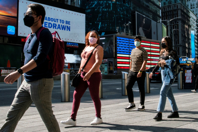 23일 미국 뉴욕의 타임스퀘어에서 신종 코로나바이러스(코로나19) 감염증 우려로 인해 시민들이 마스크를 착용한 상태로 거리를 걷고 있다. /로이터연합뉴스