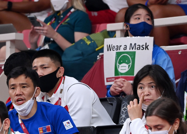 28일 일본 도쿄 일본 무도관에서 열린 유도 남자 -90kg급 32강전에서 관계자들이 마스크를 벗은 채 응원을 하고 있다. 바로 뒤에는 자원봉사자가 마스크 착용을 알리는 손팻말을 들고 있다./도쿄=권욱 기자