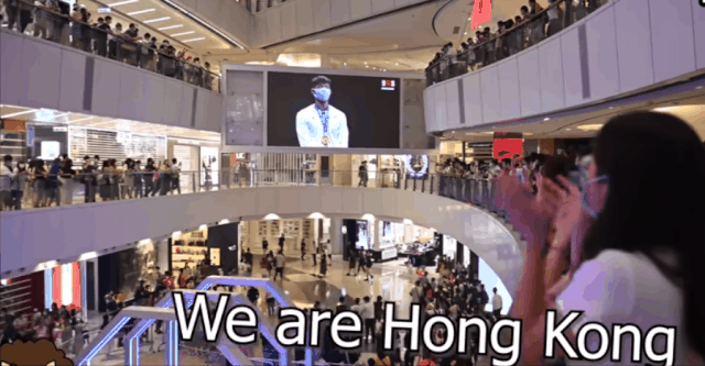 26일 홍콩 대형 쇼핑몰 APM에서 홍콩 시민들이 홍콩 펜싱 국가대표 청카룽의 시상식에서 중국 국가 연주되자 