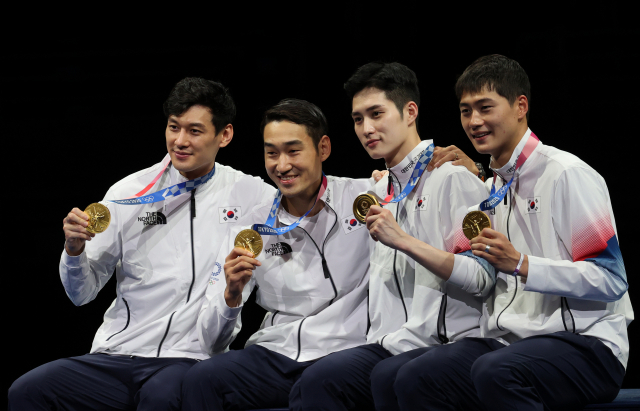 남자 펜싱 사브르 대표팀이 28일 도쿄 올림픽 단체전 금메달을 합작한 뒤 메달을 들어 보이고 있다. 왼쪽부터 구본길, 김정환, 김준호, 오상욱. /지바=권욱 기자