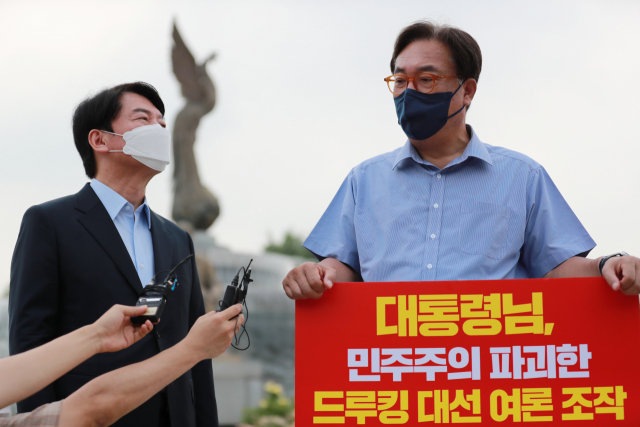 국민의당 안철수 대표(왼쪽)가 29일 오전 서울 종로구 청와대 사랑채 앞에서 '드루킹 댓글 사건' 관련 1인 시위를 벌이고 있는 국민의힘 정진석 의원을 지지 방문해 대화하고 있다. /연합뉴스