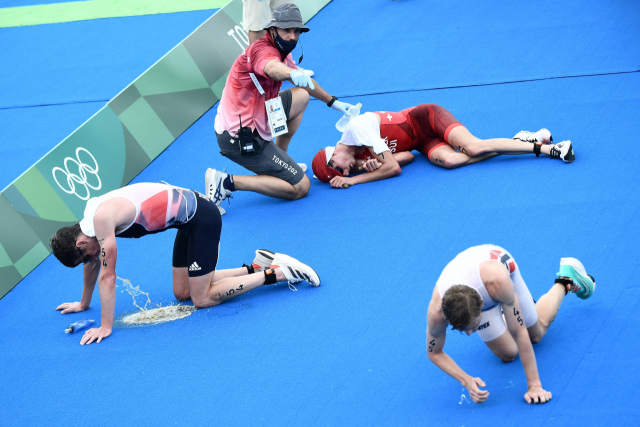 26일 일본 도쿄 오다이바 해상공원서 열린 도쿄올림픽 트라이애슬론(철인3종경기) 남자 개인전 경기를 마친 선수들이 바닥에 쓰러져 있다. 이날 선수들은 무더위에 지쳐 쓰러졌으며, 일부는 구토를 하기도 했다. /AFP연합뉴스