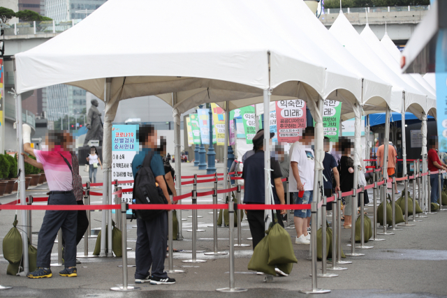 31일 서울역 광장에 마련된 중구임시선별검사소에서 시민들이 검사를 받기 위해 기다리고 있다./연합뉴스