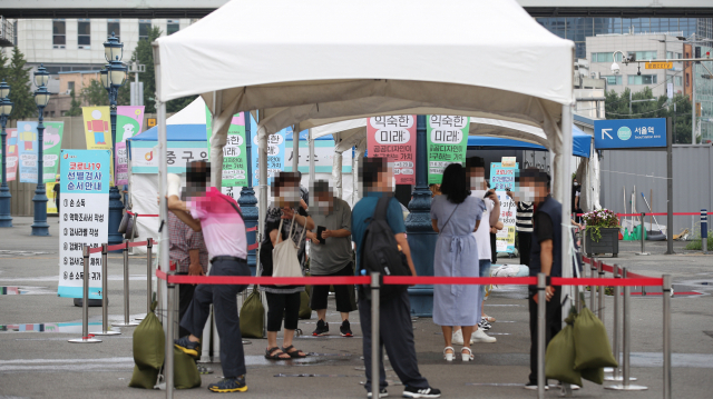 서울역 광장에 마련된 중구임시선별검사소에서 시민들이 검사를 받기 위해 기다리고 있다./연합뉴스