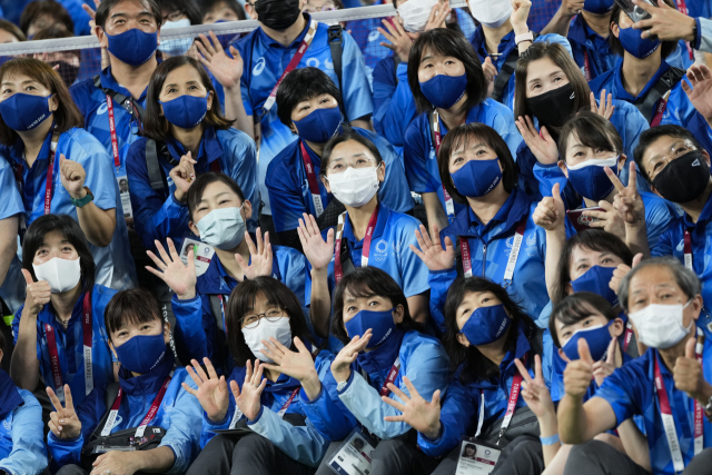 2020 도쿄 올림픽 자원봉사자들이 31일 손을 흔들고 있다. /AP연합뉴스