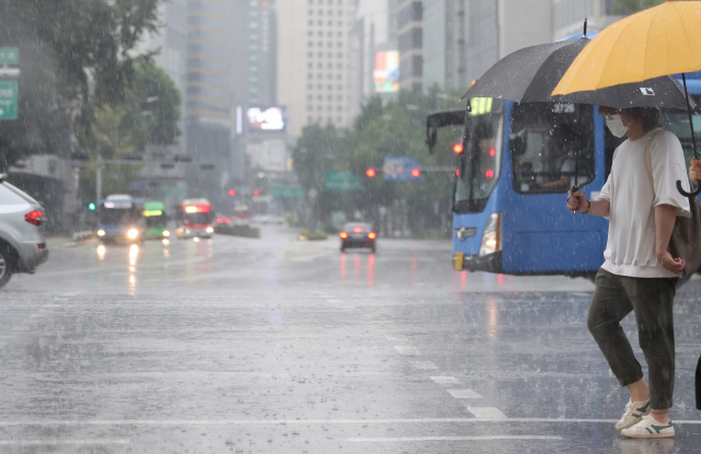소나기가 내린 지난 1일 서울 종로구에서 시민들이 우산을 쓴 채 발걸음을 옮기고 있다. /연합뉴스