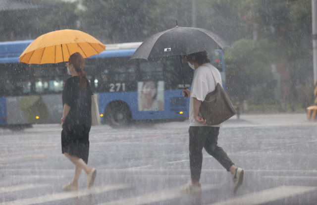 1일 서울 종로구 도로에서 시민들이 우산을 쓴 채 발걸음을 옮기고 있다. /연합뉴스