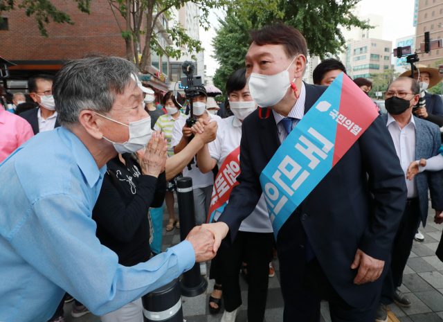 윤석열 국민의힘 대선 예비후보가 3일 오후 서울 은평구 응암역 앞에서 국민의힘 당원 가입을 독려하는 홍보 활동을 위해 이동하며 지지자들과 악수하고 있다./국회사진기자단