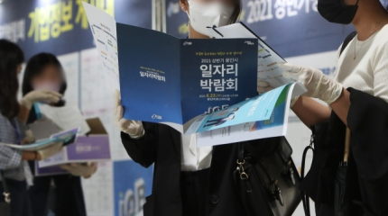 구직자들이 지난달 23일 열린 한 일자리 박람회에서 안내 책자를 살펴보고 있다. / 연합뉴스